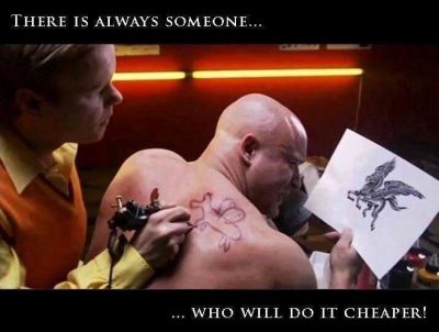 A tattoo artist putting a childish looking tattoo of a dragon on a man's back that is nothing like the picture he is holding in his hand.
